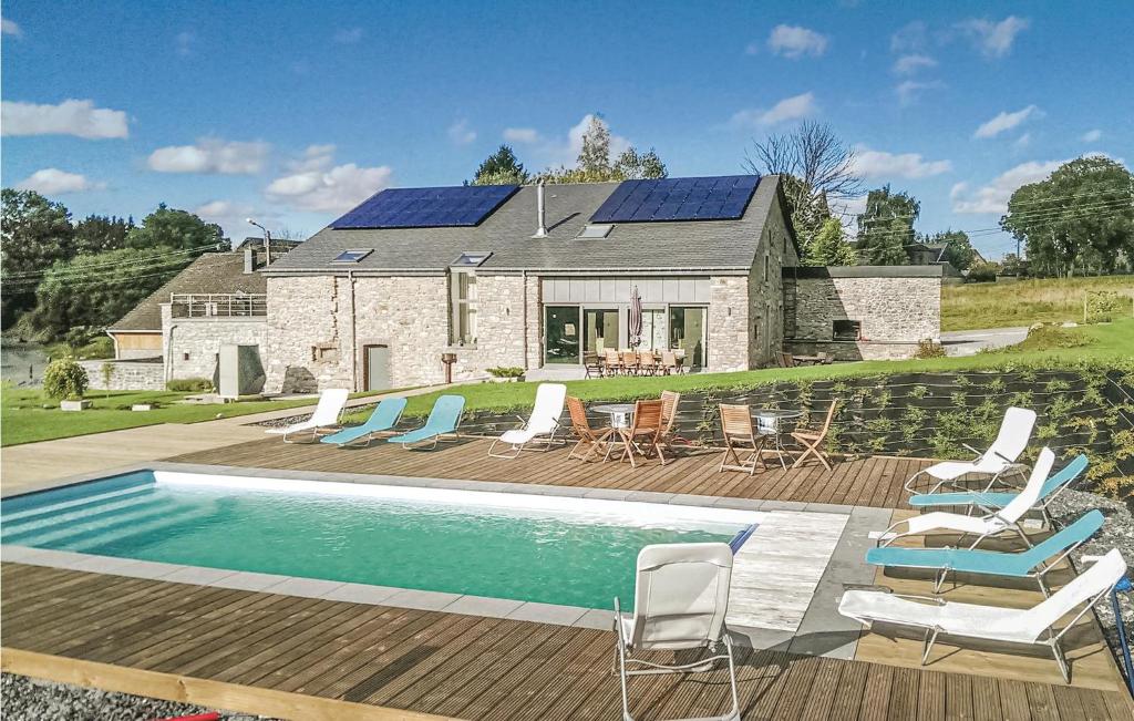 ein Haus mit einem Pool mit Stühlen und einem Haus mit Sonnenkollektoren in der Unterkunft Les Brumes in Manhay
