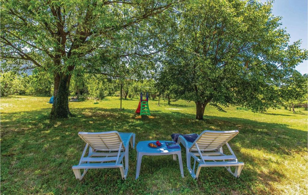 2 chaises et une table dans la pelouse avec une aire de jeux dans l'établissement Awesome Home In Skrljevo With Wifi, à Škrljevo