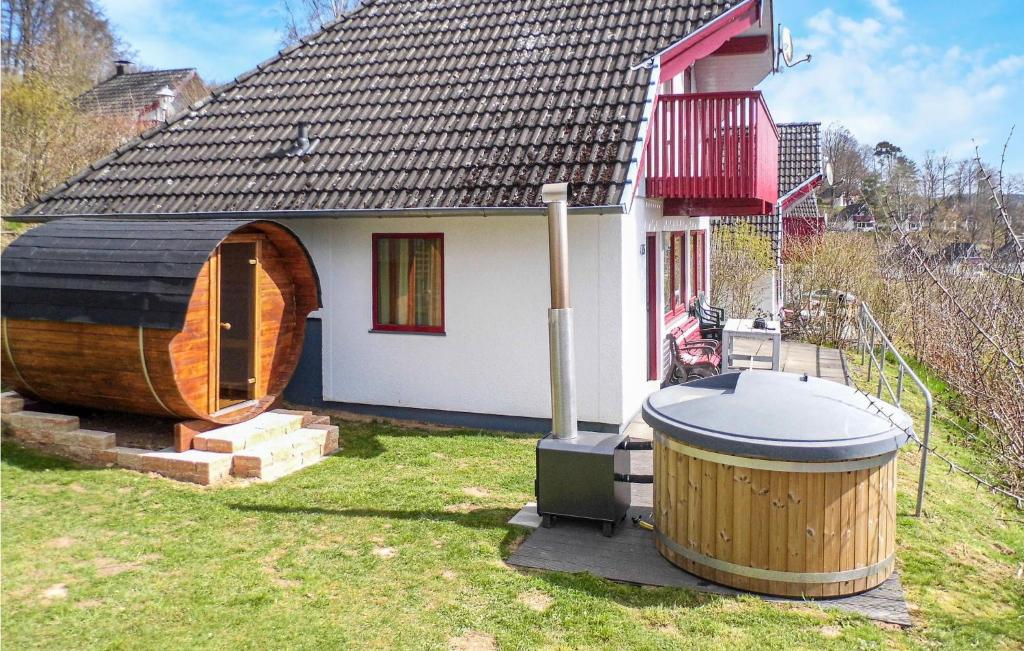 ein kleines Haus mit einer großen Holzbadewanne daneben in der Unterkunft Ferienhaus 45 In Kirchheim in Kemmerode