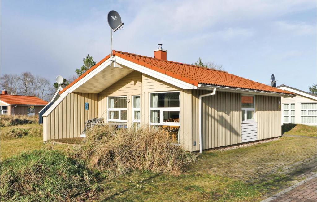 a small house with an orange roof on a field at Schmugglerstieg 2 - Dorf 6 in Priwall