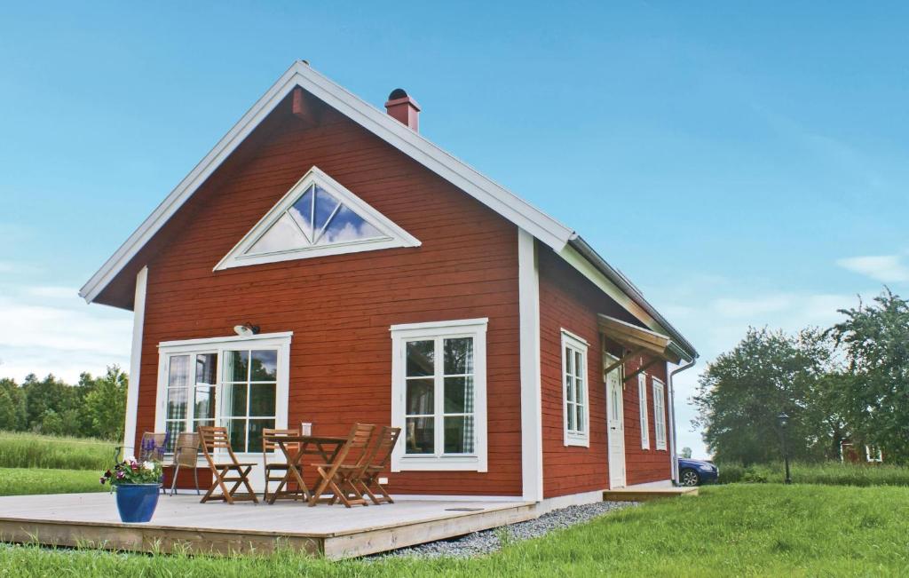 uma pequena casa vermelha com cadeiras e uma mesa em Nice Home In Vetlanda With Wifi em Skirö