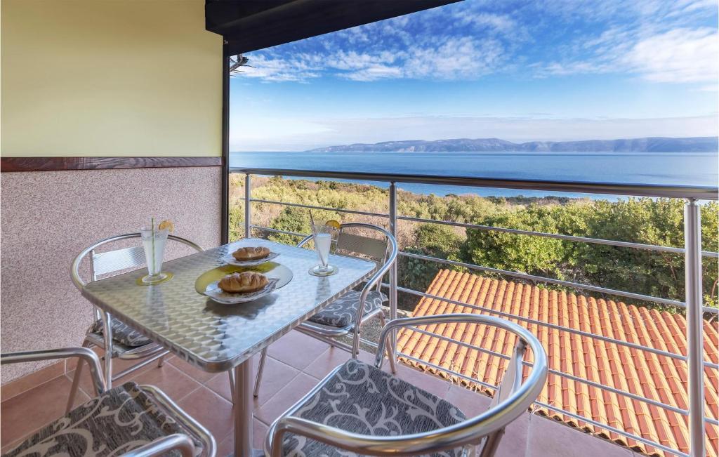 un tavolo e sedie su un balcone con vista sull'oceano di Pet Friendly Apartment In Labin With Kitchen a Labin