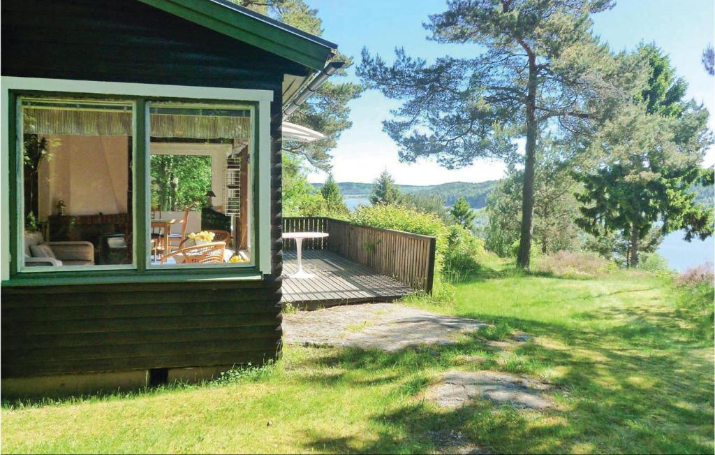 una casa con terraza de madera junto a un patio en Bergsvik, en Munkedal