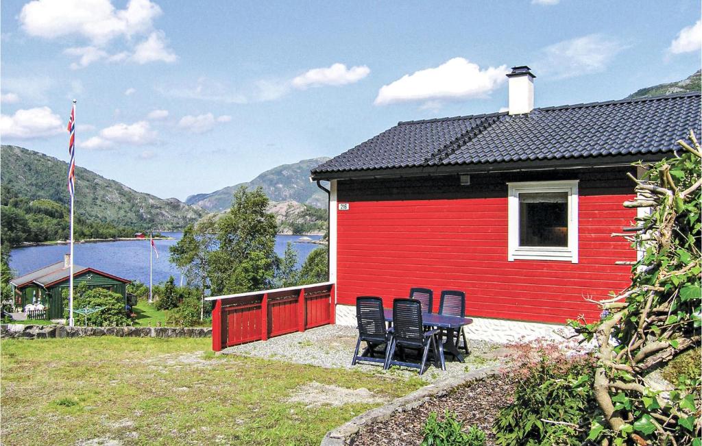 a red house with chairs and a table in front of it at Nice Home In Dalsyra With 4 Bedrooms And Wifi in Oppdalsøyra