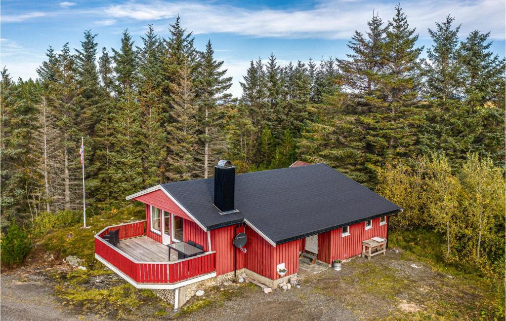 een rood huis met een zwart dak in het bos bij Amazing Home In Farstad With House Sea View in Farstad