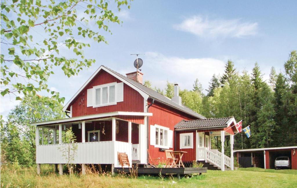 a red and white house with a porch at Nice Home In Lesjfors With 3 Bedrooms And Sauna in Kosundet