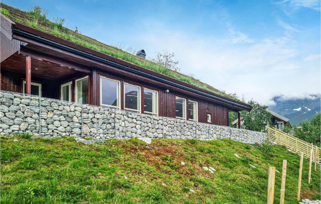 a house with a grass roof and a stone wall at Awesome Home In Stordal With Wifi in Vinje