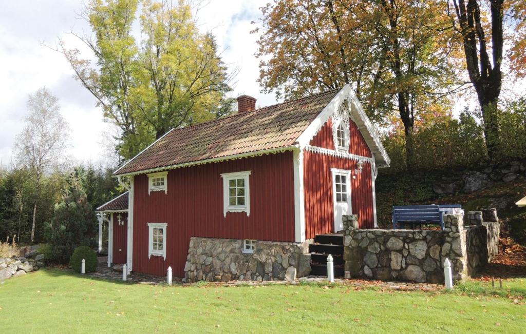 uma casa vermelha com uma parede de pedra num quintal em 2 Bedroom Gorgeous Home In Rrvik em Rörvik