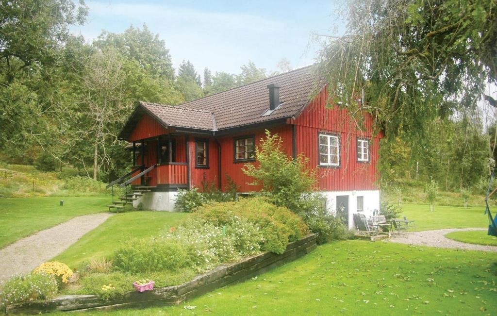 a red house with a garden in front of it at Cozy Home In Uddevalla With Wifi in Häljebol