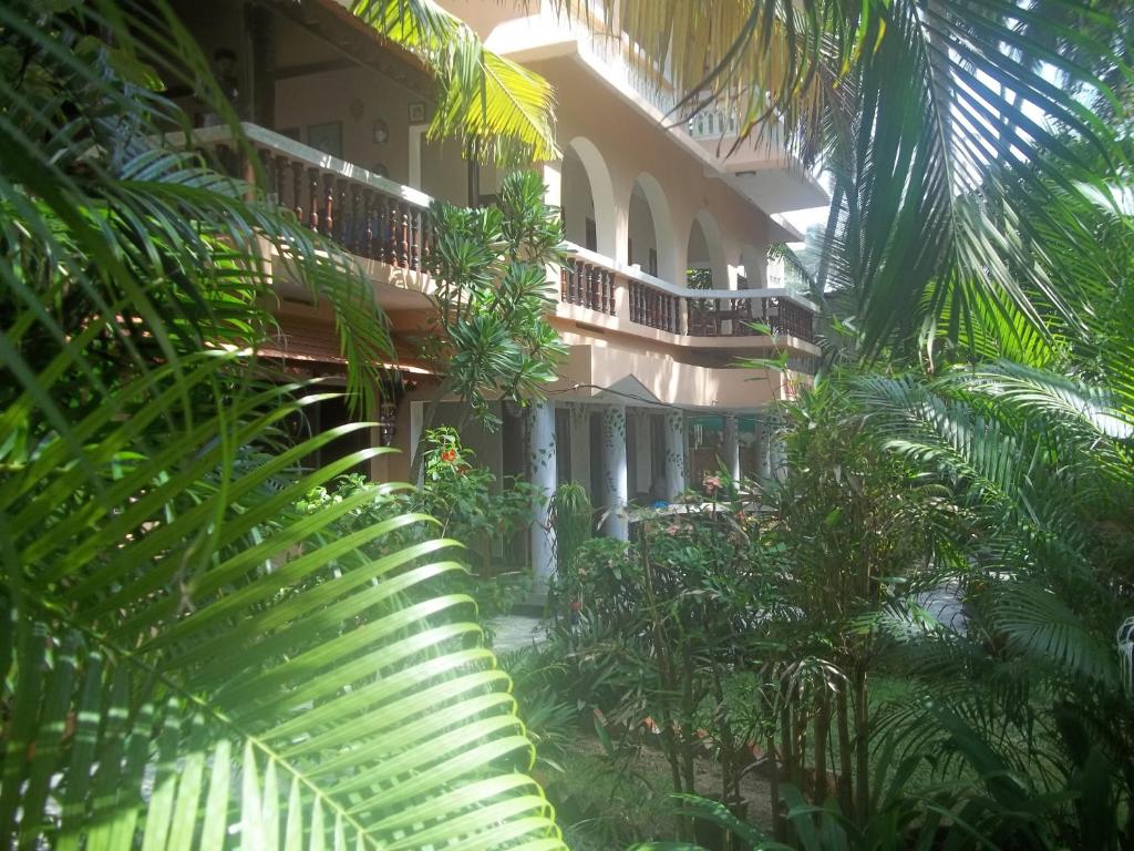 a building with palm trees in front of it at Maharaju Palace in Kovalam