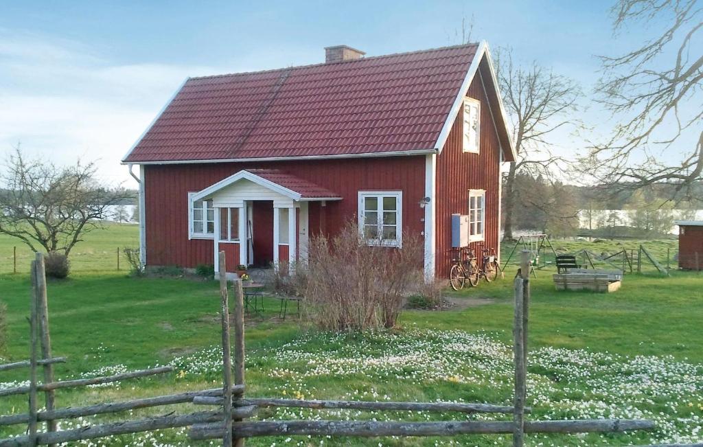 uma casa vermelha com um telhado vermelho num campo em Amazing Home In Vrnamo With Kitchen em Värnamo