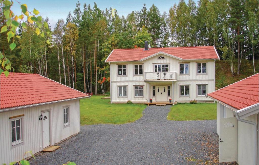 a large white house with a red roof and two garages at Beautiful Home In Jnkping With 5 Bedrooms, Wifi And Indoor Swimming Pool in Norrahammar