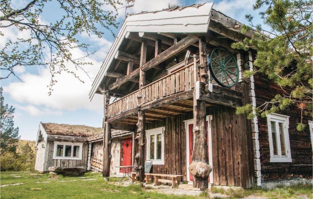 Trøan的住宿－Savalen Hestesenter，一座带红色门的古老木屋