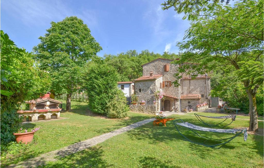 an old stone house in a yard with a swing at Il Mulino Del Bonano in Talla