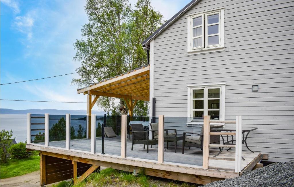 a deck with a table and chairs on a house at Cozy Home In Ballangen With Wifi in Ballangen