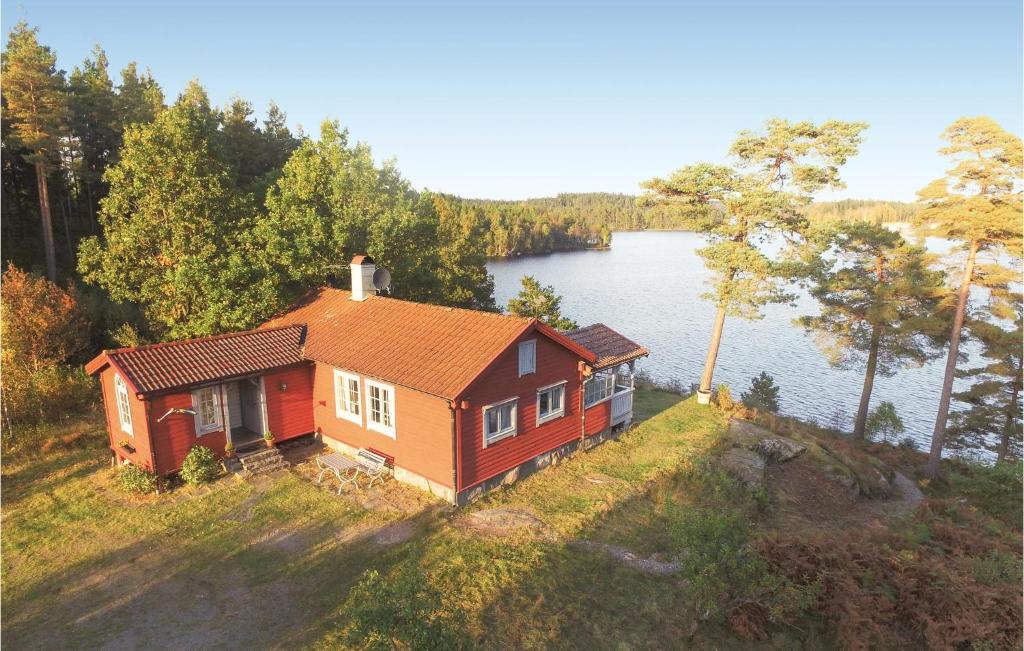 a small house on a hill next to a lake at Awesome Home In Landvetter With Kitchen in Landvetter