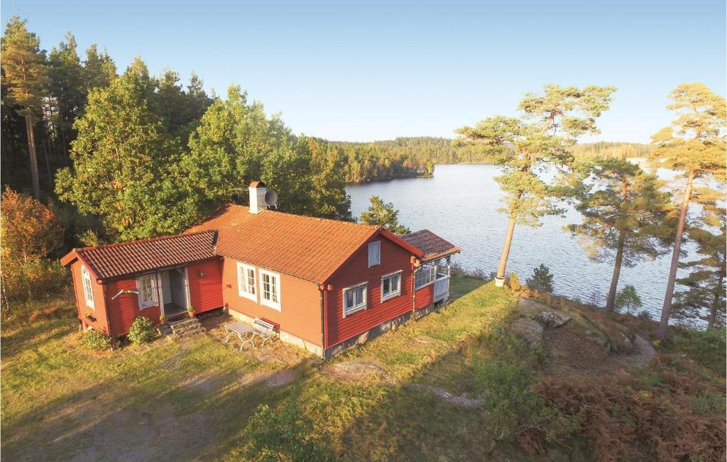 a small house on a hill next to a lake at Stunning Home In Landvetter With 2 Bedrooms, Sauna And Wifi in Landvetter