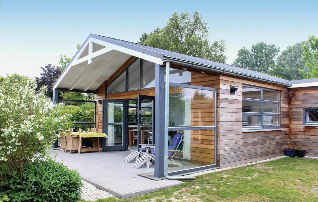 una casa con una gran puerta de cristal en un patio en Das Sommerhus 68, en Noordwijk