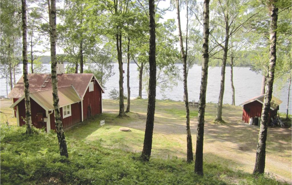 HyltebrukにあるAmazing Home In Hyltebruk With 3 Bedrooms And Wifiの水の横の森の赤い家