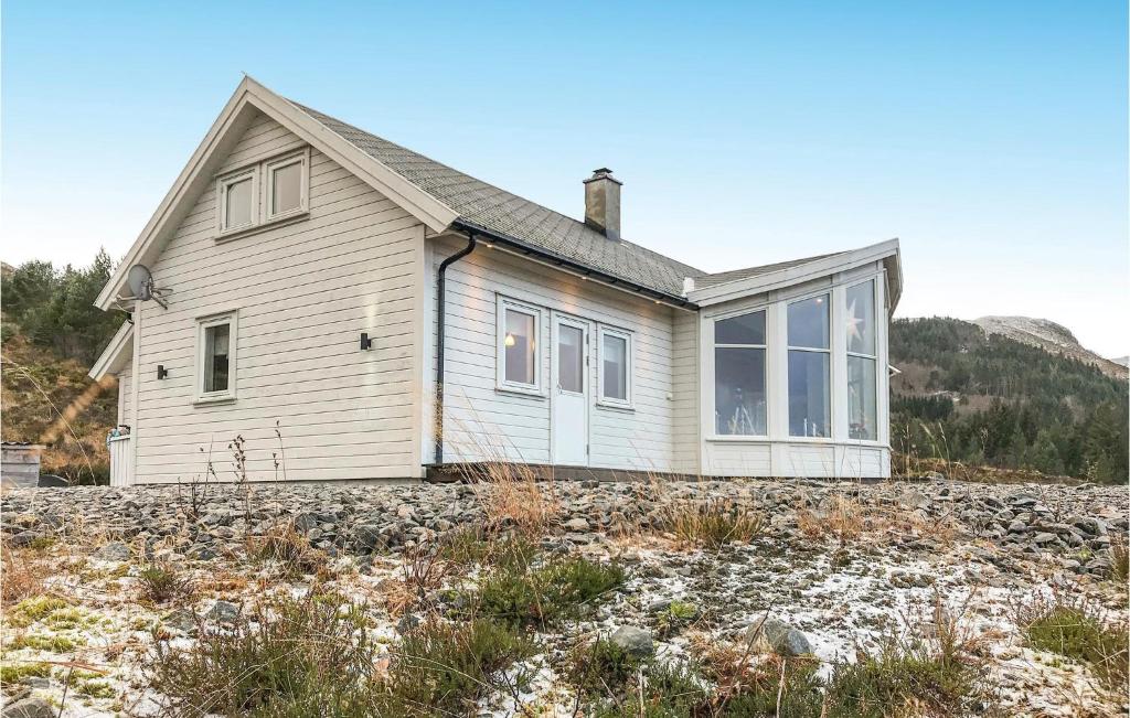 uma pequena casa numa colina rochosa com uma casa em Nice Home In Stadlandet With House A Mountain View em Hundsnes
