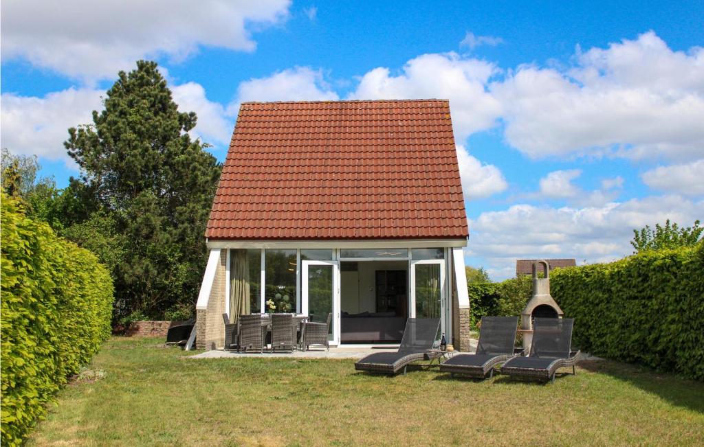 un grupo de sillas y una casa con techo en Stunning Home In Vlagtwedde With House Sea View, en Vlagtwedde
