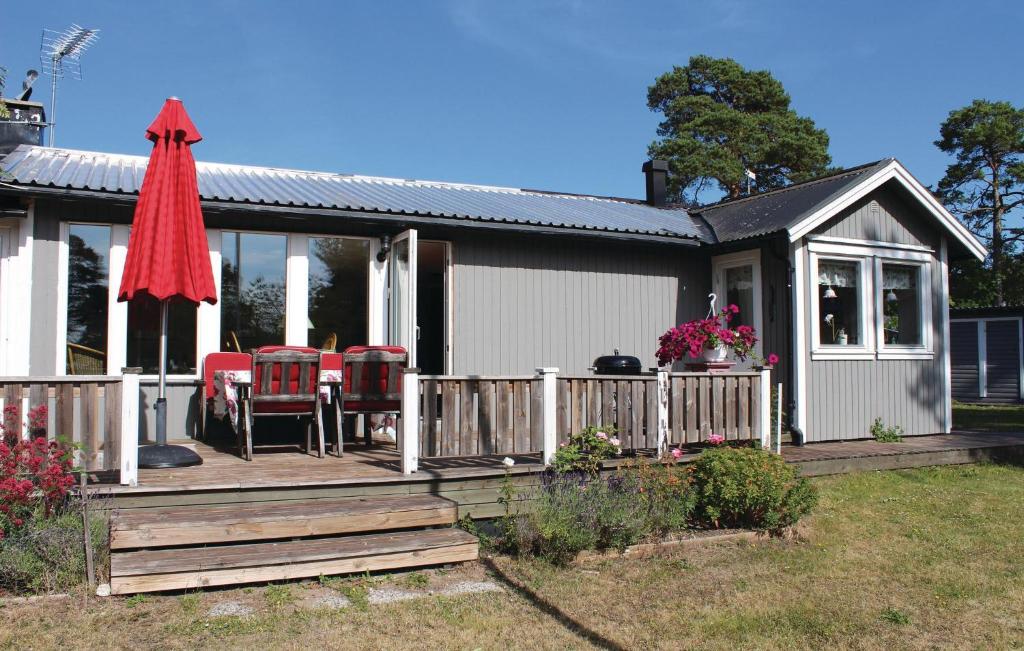 VallevikenにあるBeautiful Home In Lrbro With 3 Bedroomsのデッキ(テーブル、椅子付)が備わる家