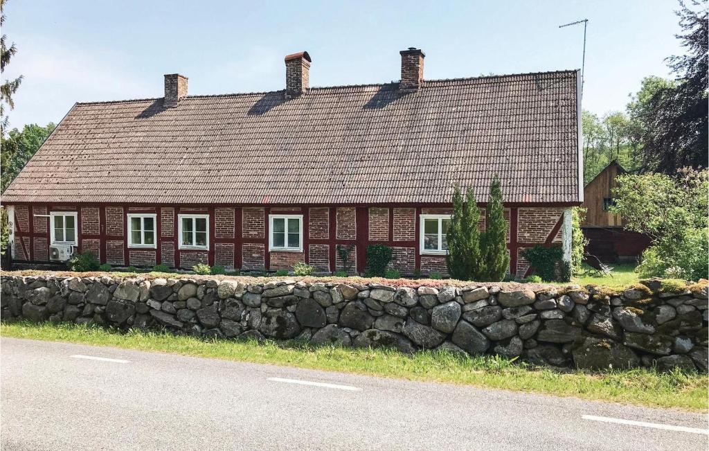 ein Backsteinhaus mit einer Steinmauer neben einer Straße in der Unterkunft Gorgeous Home In Vinslv With Wifi in Vinslöv