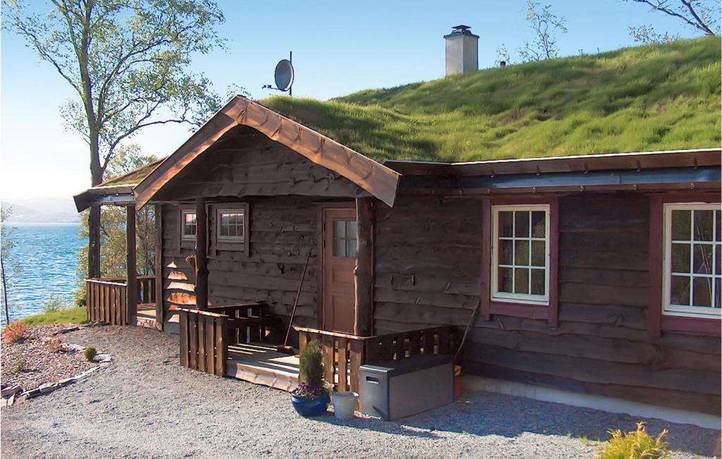 a log cabin with a grassy hill on top of it at Eikhaugen Gjestegard in Vinnes