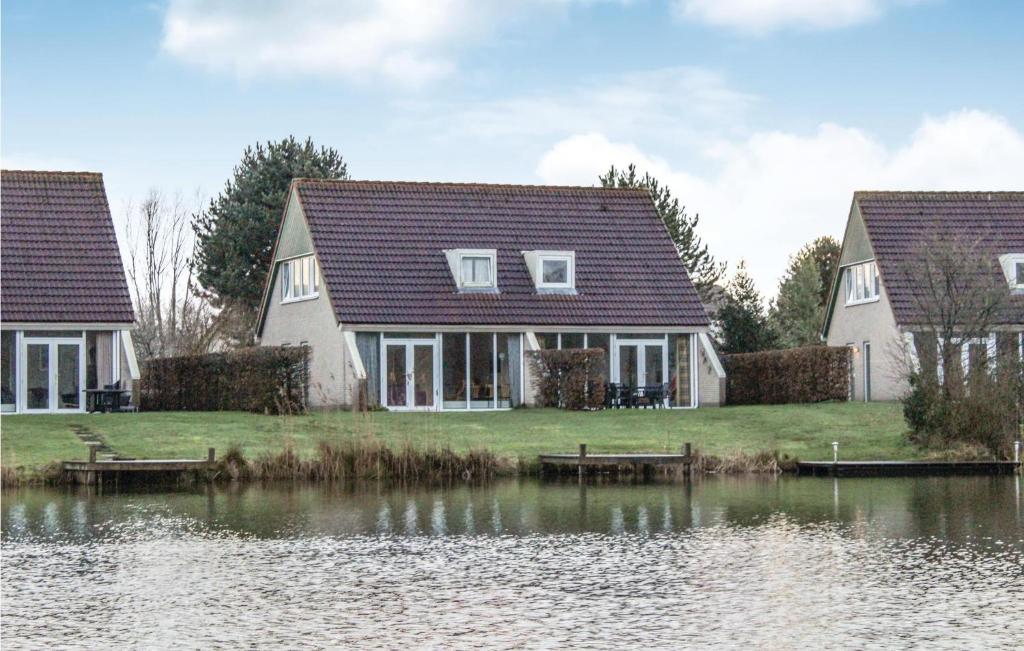 Deux maisons à côté d'une masse d'eau dans l'établissement Amazing Home In Vlagtwedde With House Sea View, à Vlagtwedde
