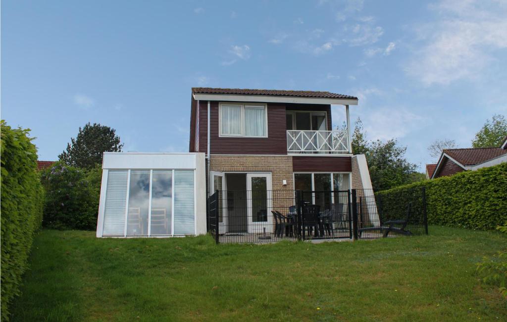 Casa con balcón y mesa en el césped en Cozy Home In Vlagtwedde With Indoor Swimming Pool en Vlagtwedde