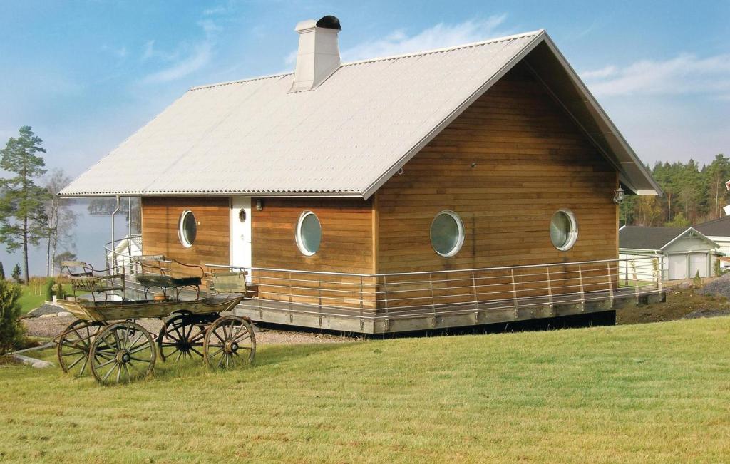 a large wooden house with a horse drawn carriage at Nice Home In Mnsarp With Kitchen in Bondstorp
