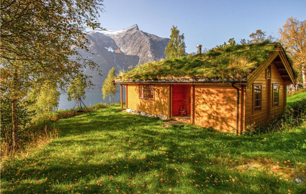 an old house with a grass roof with a mountain in the background at Nice Home In Eikesdal With 2 Bedrooms And Internet in Øverås