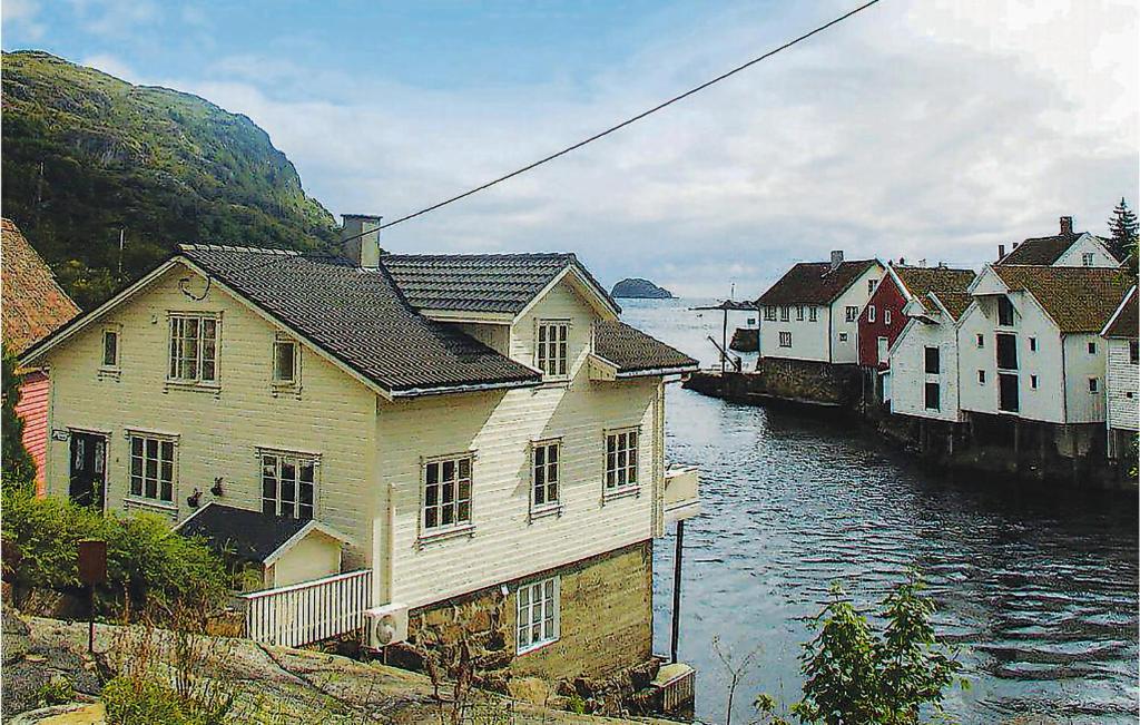 a group of houses next to a body of water at Gorgeous Apartment In Hauge I Dalane With House Sea View in Sogndalsstrand