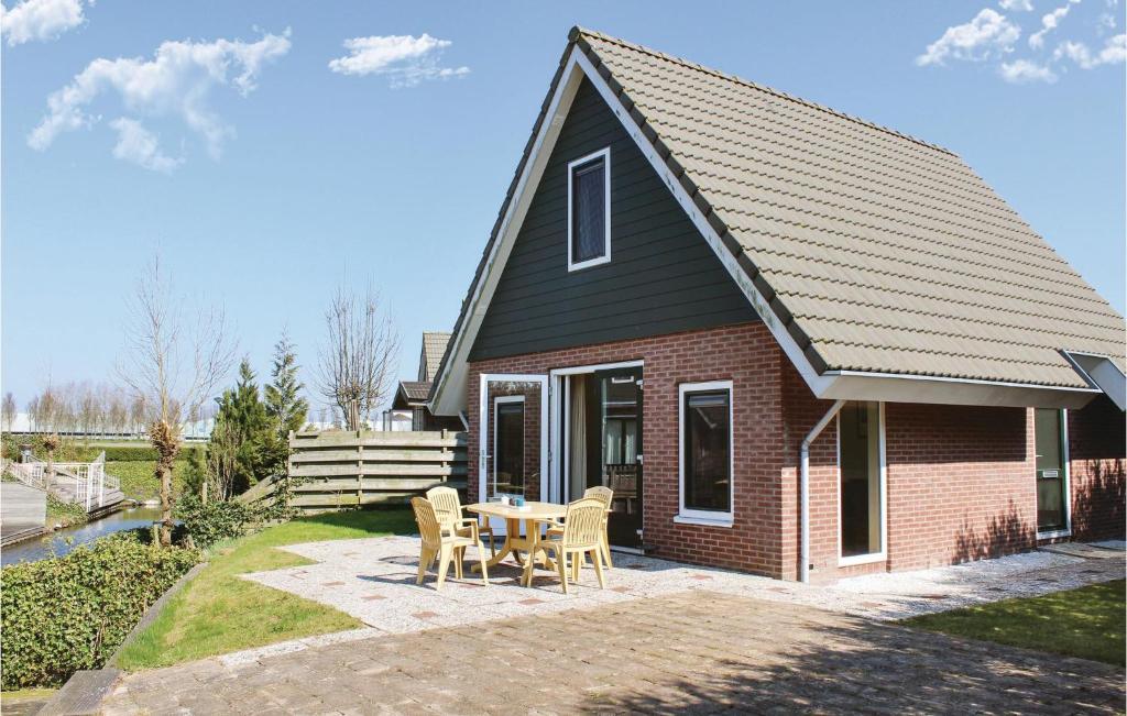 een huis met een tafel en stoelen ervoor bij Stunning Home In Opperdoes With 2 Bedrooms And Wifi in Opperdoes