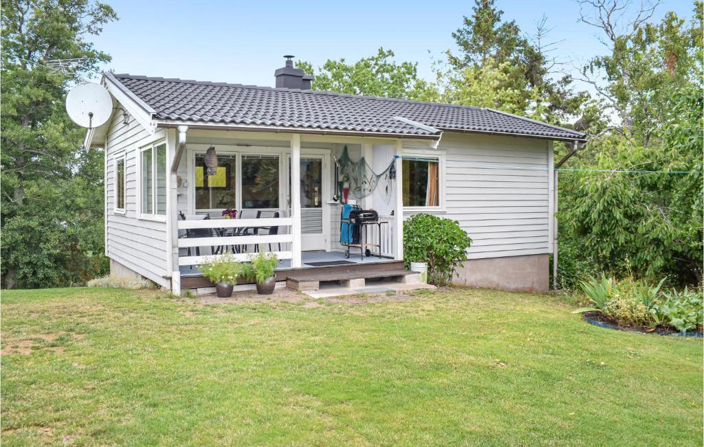 a small white house with a porch and a yard at Awesome Home In Oskarshamn With 1 Bedrooms And Wifi in Oskarshamn