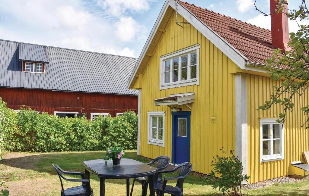 una casa amarilla con una mesa delante en Pet Friendly Home In Mariannelund With Kitchen, en Mariannelund