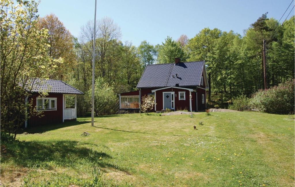 een klein huis in een tuin met een grasveld bij Lovely Home In Olofstrm With Sauna in Olofström