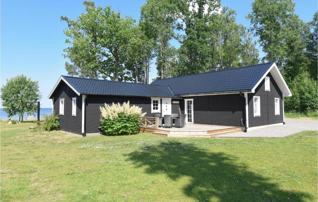 un cobertizo negro con porche y patio en Nice Home In Sjtorp With Kitchen, en Sjötorp