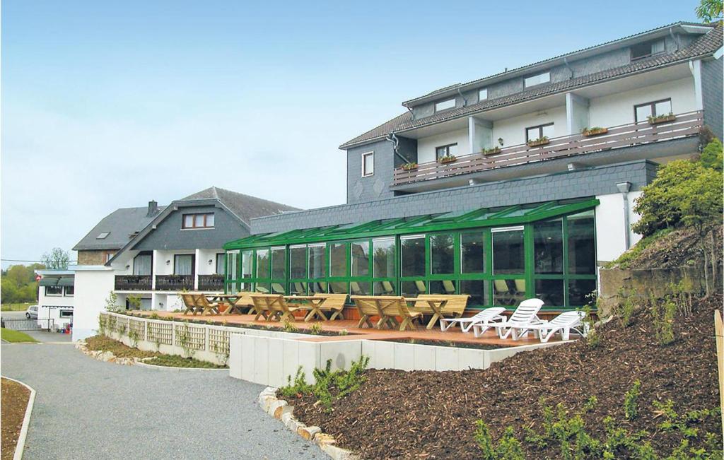 a building with tables and chairs in front of it at Hotel Drosson in Wirtzfeld