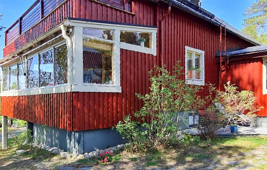 ein rotes Haus mit weißen Fenstern an der Seite in der Unterkunft Lovely Home In Storsvartrsk With Kitchen 