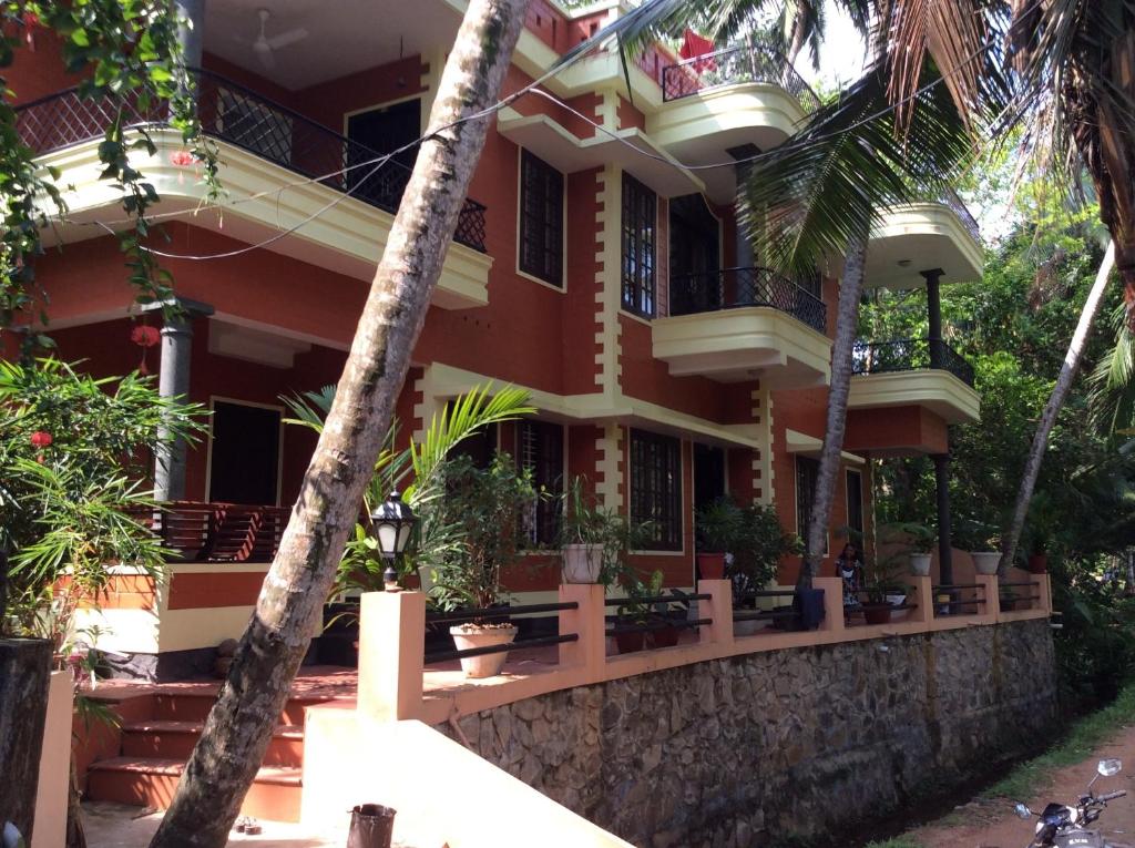 a house with palm trees in front of it at Reuben Villa in Kovalam