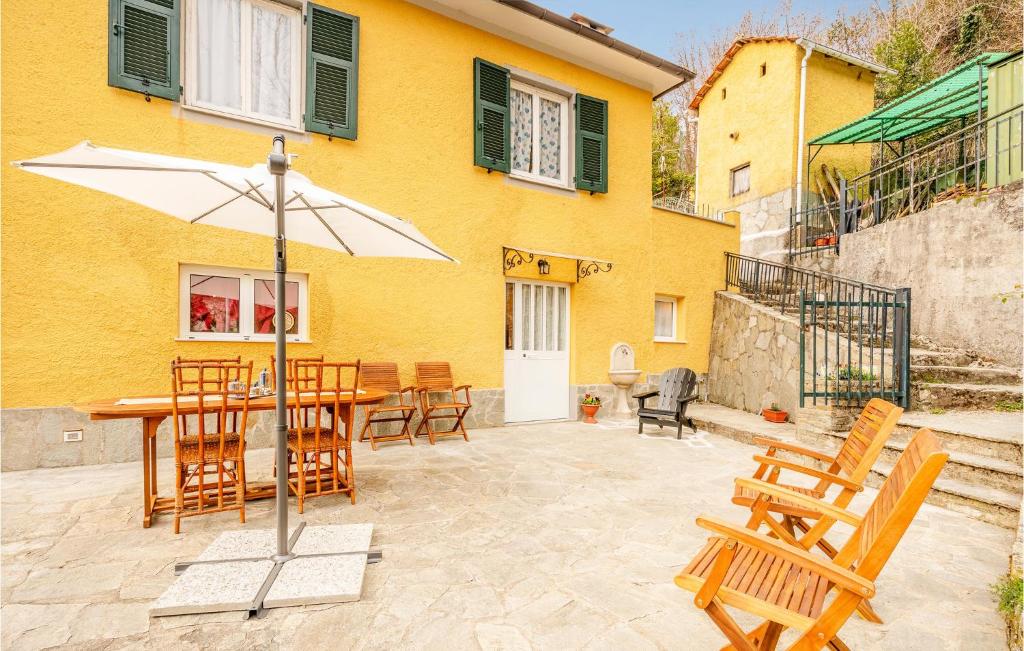 une terrasse avec une table, des chaises et un parasol dans l'établissement Beautiful Home In Borzonasca With Wifi, à Borzonasca