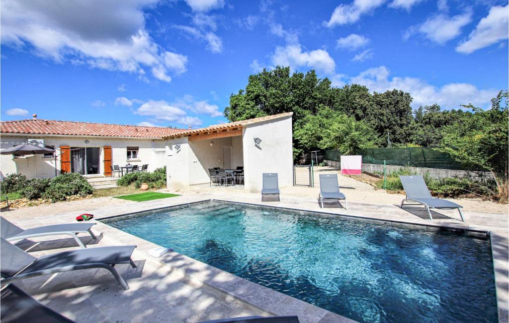 une piscine avec des chaises et une maison dans l'établissement Pet Friendly Home In Rochefort Du Gard, à Rochefort-du-Gard