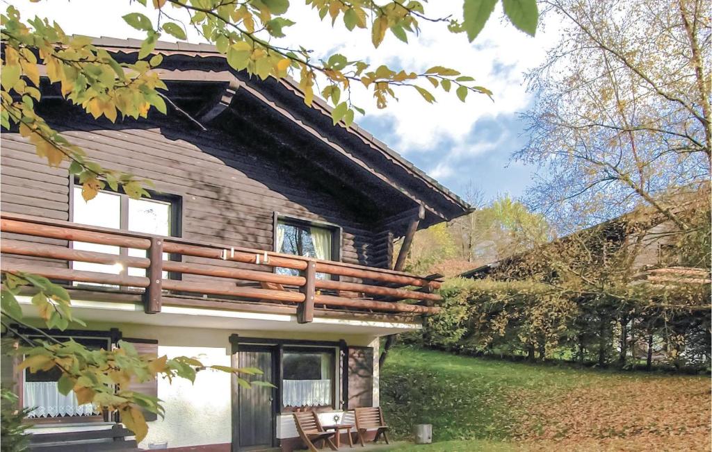 una casa de madera con porche y sillas al aire libre en Nice Apartment In Schnecken With Wifi en Schönecken