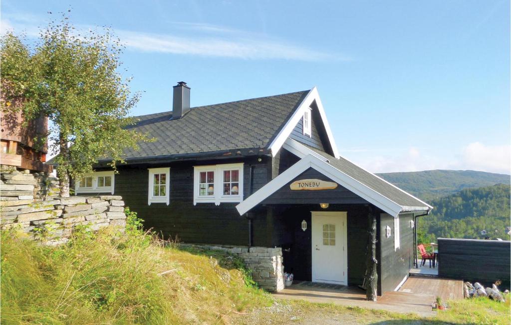 una casa nera con una porta bianca di 5 Bedroom Cozy Home In Norheimsund a Norheimsund