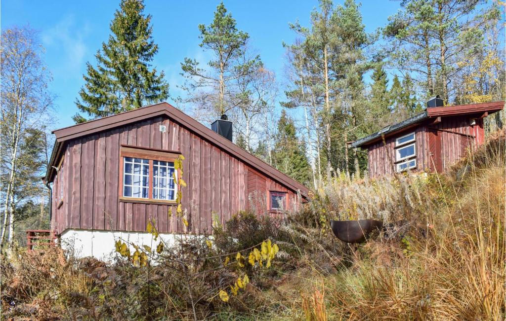 a red barn in the middle of a forest at Amazing Home In Kvinesdal With 2 Bedrooms And Sauna in Kvinesdal