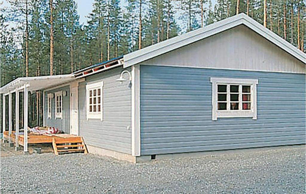 um pequeno edifício azul com um alpendre e árvores em Beautiful Home In Hede With 3 Bedrooms And Sauna em Hedeviken