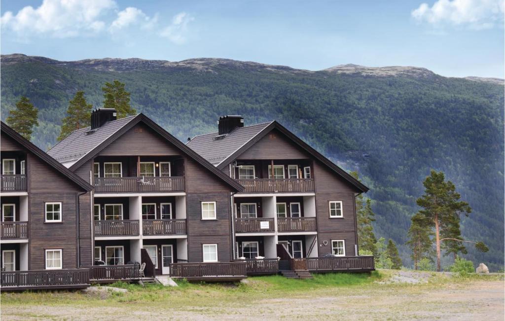 a large wooden building with mountains in the background at Gorgeous Apartment In Uvdal With Wifi in Uvdal