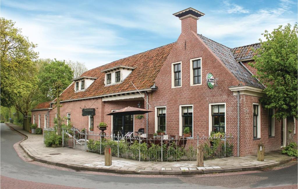 Cozy Home In Visvliet With Kitchen في Visvliet: مبنى من الطوب الأحمر مع مطعم على شارع