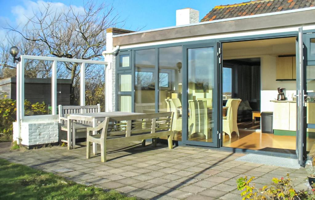 a conservatory with a table and chairs on a patio at Bellevue in Bergen aan Zee